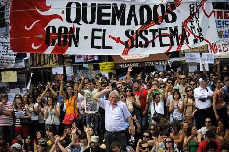 MADRID, SPAIN - MAY 22: Demonstrators shout slogans at the Sol Square Camp during a continued protest on May 22, 2011 in Madrid, Spain. Despite a ban on political protests ahead of Spain's regional elections about thirty thousand demonstrators, angry with the high youth unemployment and economic policies, have gathered in the capital's central Puerta del Sol. (Photo by David Ramos/Getty Images)
